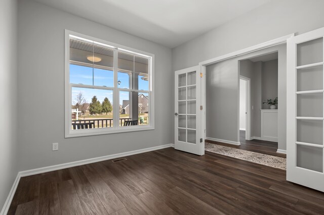 4030 Hollow Wood Dr, Portage, MI 49024 - spare room with french doors, dark wood-type flooring, and baseboards