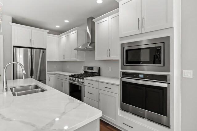 4030 Hollow Wood Dr, Portage, MI 49024 - kitchen with recessed lighting, a sink, white cabinets, appliances with stainless steel finishes, and wall chimney exhaust hood