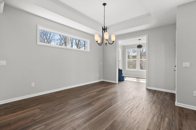 4030 Hollow Wood Dr, Portage, MI 49024 - spare room with a notable chandelier, dark wood-type flooring, baseboards, and a tray ceiling
