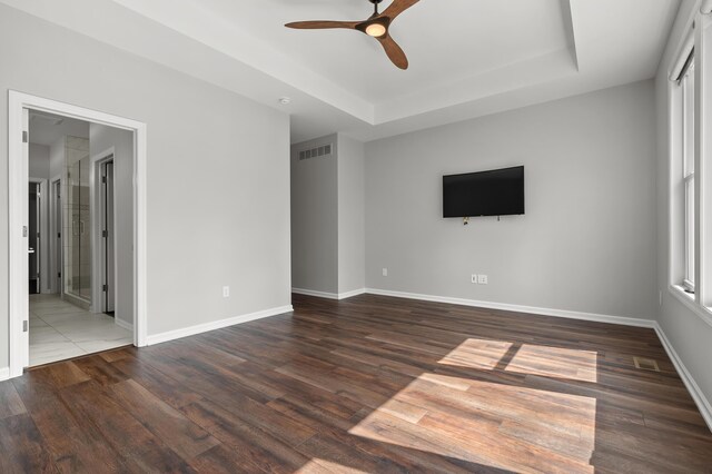 4030 Hollow Wood Dr, Portage, MI 49024 - unfurnished living room featuring a tray ceiling, visible vents, a ceiling fan, and wood finished floors