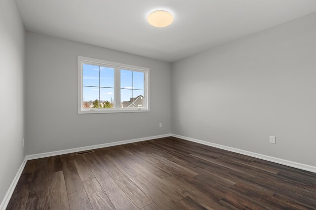 4030 Hollow Wood Dr, Portage, MI 49024 - unfurnished room with dark wood-style floors, baseboards, and visible vents