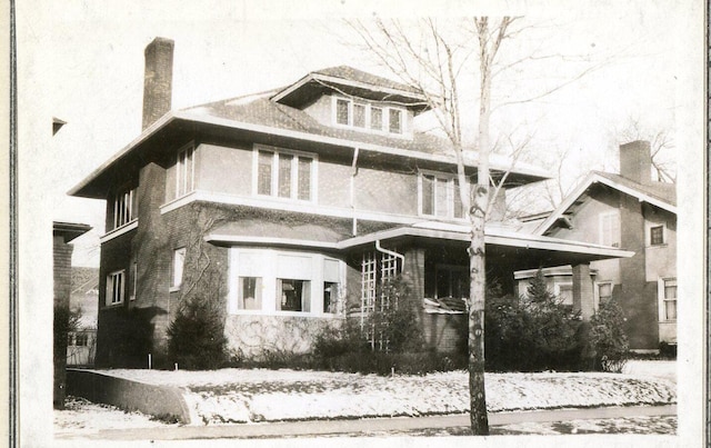 view of snow covered exterior featuring a chimney