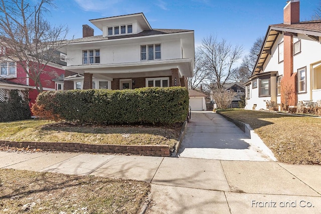 american foursquare style home with an outdoor structure, a detached garage, and stucco siding