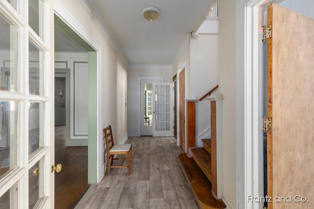 interior space with crown molding, baseboards, stairway, french doors, and wood finished floors