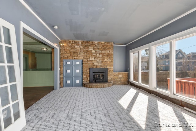 unfurnished living room featuring carpet flooring, ornamental molding, and a fireplace