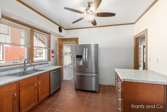 kitchen featuring a sink, stainless steel appliances, light countertops, crown molding, and brown cabinets