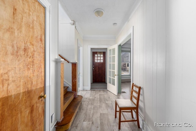 entryway with stairway, french doors, and wood finished floors