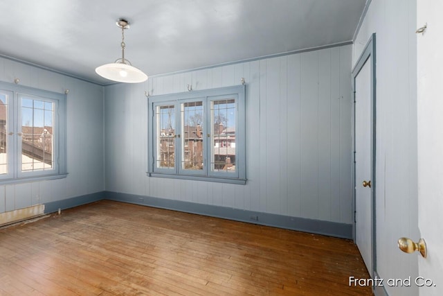 spare room featuring baseboards and wood-type flooring