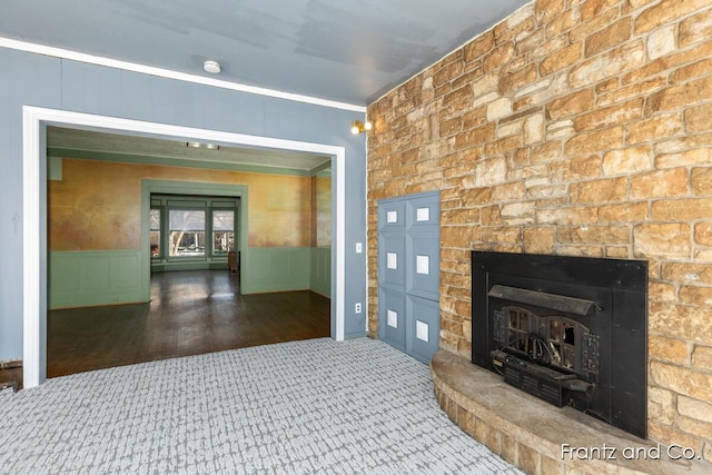 hallway featuring a decorative wall, carpet flooring, and a wainscoted wall