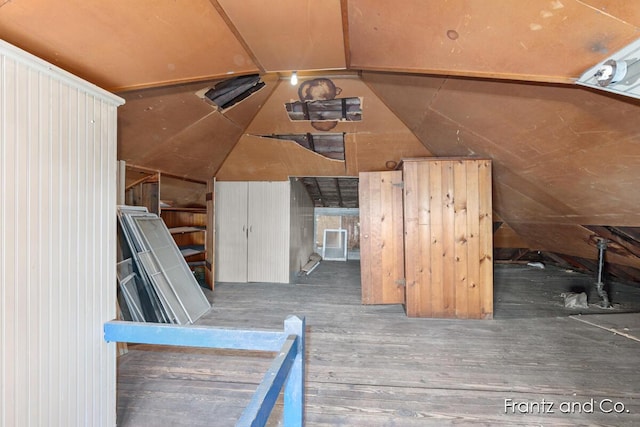 additional living space featuring wood finished floors and vaulted ceiling