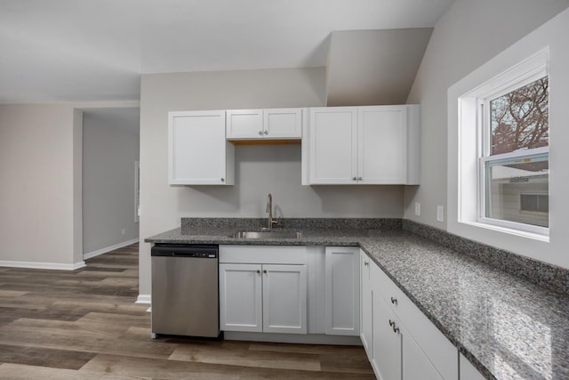 kitchen with baseboards, white cabinets, dark wood-style floors, stainless steel dishwasher, and a sink