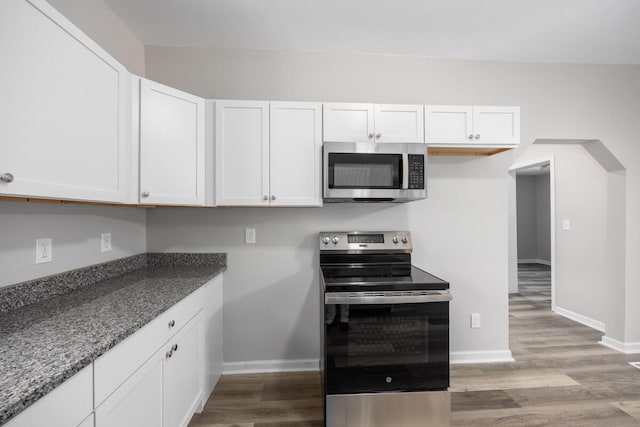 kitchen featuring white cabinets, light wood-type flooring, baseboards, and stainless steel appliances