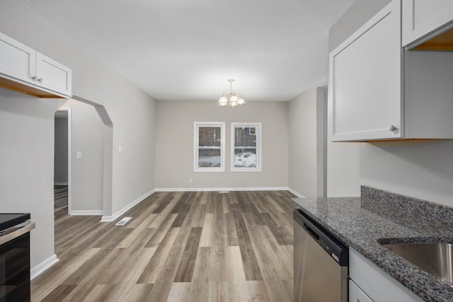 kitchen featuring stainless steel appliances, visible vents, white cabinets, light wood-type flooring, and dark stone countertops