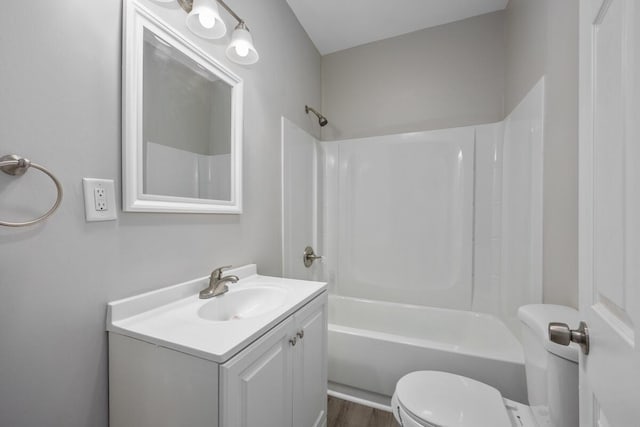 full bath featuring wood finished floors, shower / bathing tub combination, vanity, and toilet