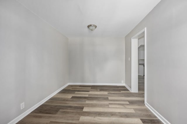 spare room featuring wood finished floors and baseboards