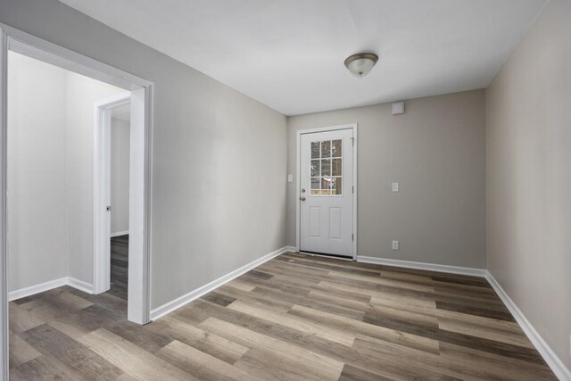 doorway to outside with baseboards and wood finished floors