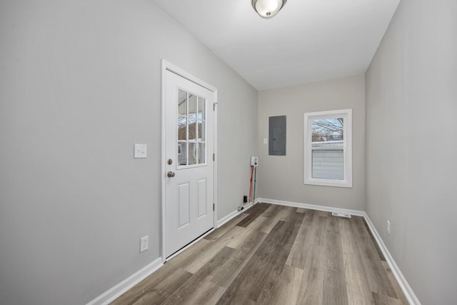 doorway featuring visible vents, wood finished floors, electric panel, and baseboards