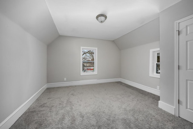 additional living space featuring vaulted ceiling, carpet floors, and baseboards