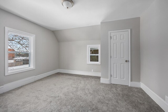 additional living space with carpet floors, lofted ceiling, and baseboards