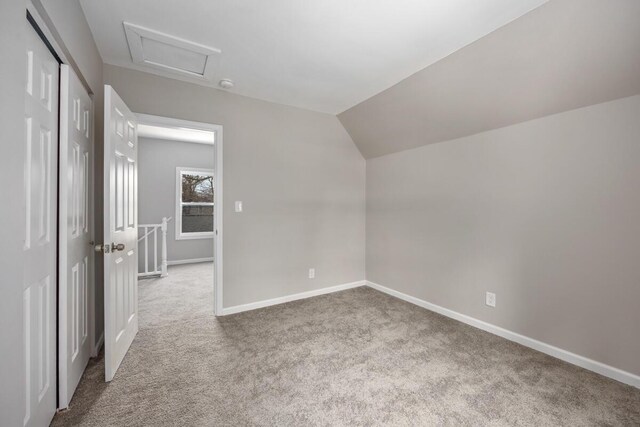 bonus room featuring vaulted ceiling, carpet, attic access, and baseboards