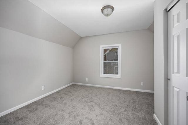 bonus room featuring lofted ceiling, carpet floors, and baseboards