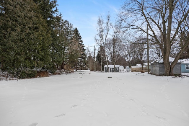 yard layered in snow featuring an outbuilding