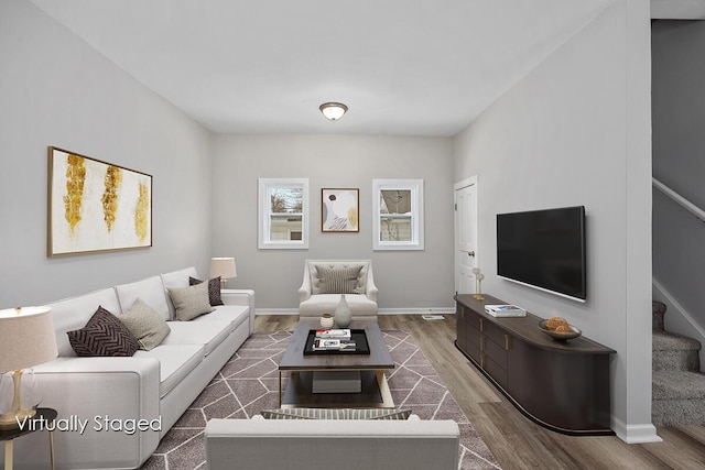 living area with stairway, wood finished floors, and baseboards