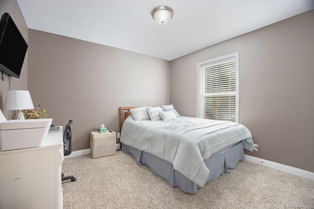 bedroom with light carpet and baseboards