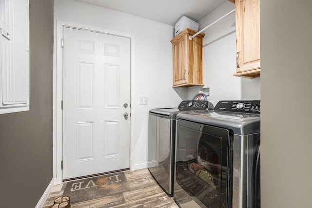 laundry area featuring cabinet space, independent washer and dryer, baseboards, and light wood-style floors