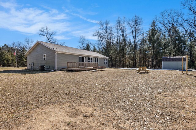 exterior space with an outbuilding, central AC, a deck, and a storage shed