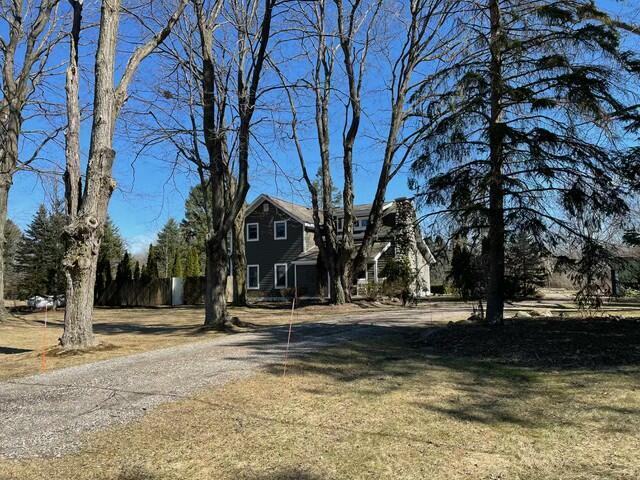 view of front of home featuring a front yard and dirt driveway