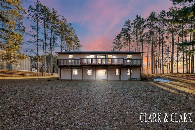 back of property at dusk featuring a deck