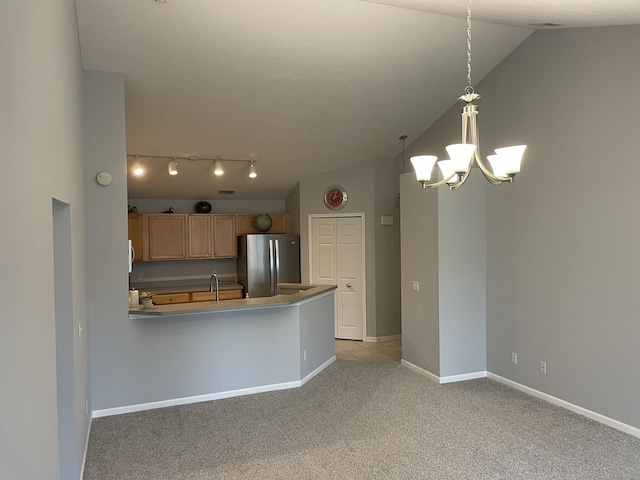 kitchen featuring baseboards, a chandelier, vaulted ceiling, light carpet, and freestanding refrigerator
