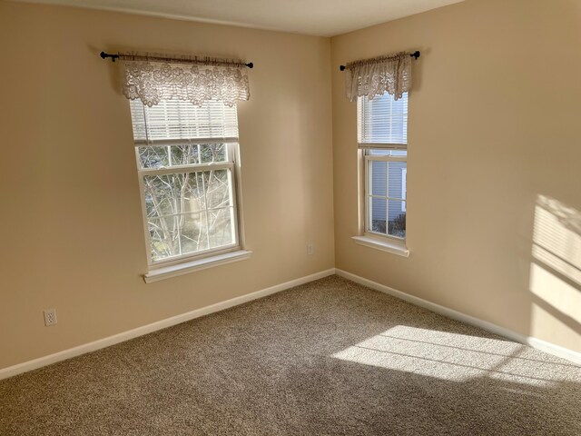 carpeted spare room featuring baseboards