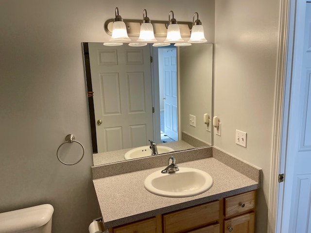 half bathroom with vanity and toilet