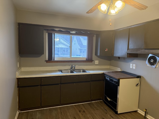 kitchen featuring dark wood finished floors, light countertops, a sink, and dishwasher