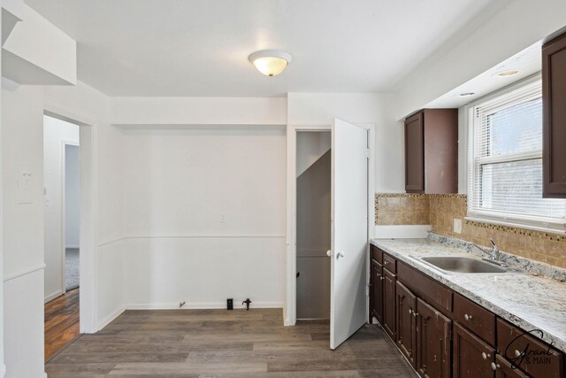 11620 Rossiter St, Detroit, MI 48224 - kitchen featuring dark brown cabinetry, wood finished floors, a sink, light countertops, and tasteful backsplash