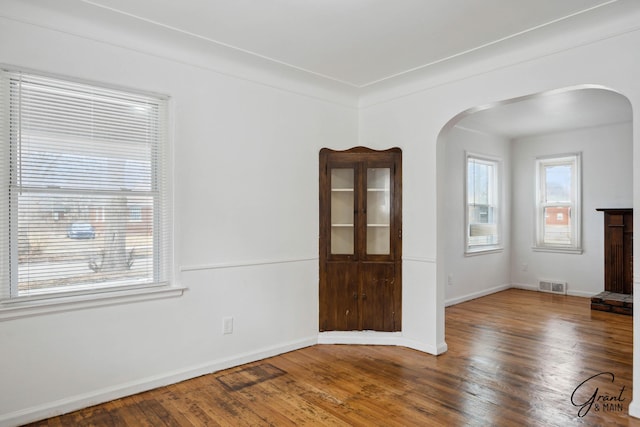 11620 Rossiter St, Detroit, MI 48224 - spare room featuring arched walkways, hardwood / wood-style floors, visible vents, and baseboards