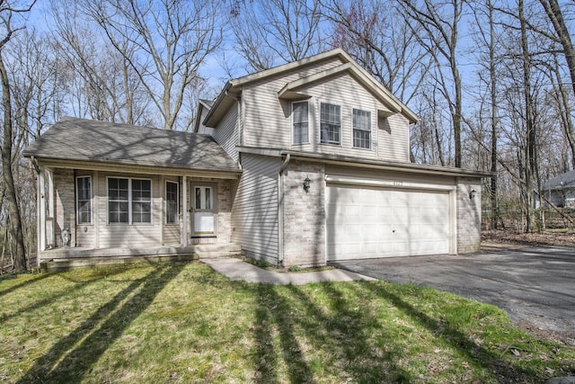 tri-level home with brick siding, aphalt driveway, a front lawn, and an attached garage