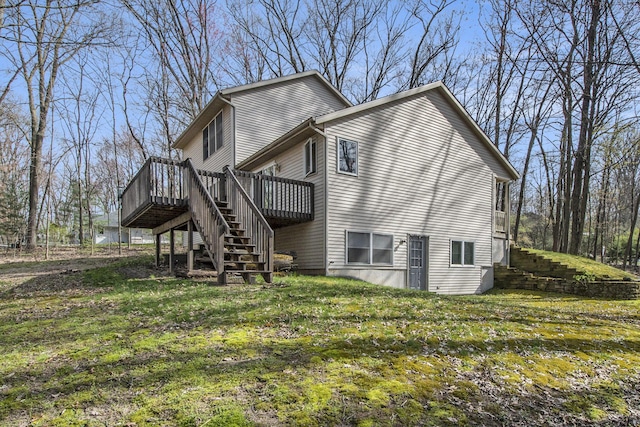 back of property featuring stairway, a wooden deck, and a yard