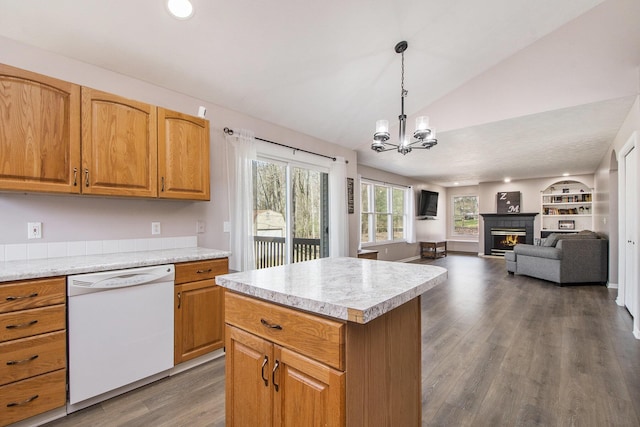 kitchen featuring vaulted ceiling, wood finished floors, light countertops, and white dishwasher