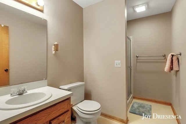 full bathroom with vanity, toilet, baseboards, and a stall shower