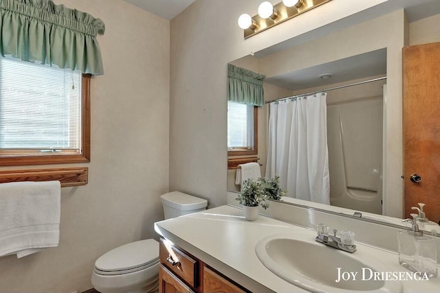 bathroom with curtained shower, toilet, and vanity