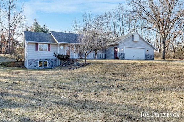 ranch-style home featuring stone siding, an attached garage, and a front lawn