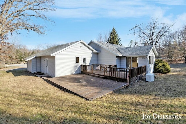 rear view of property featuring a wooden deck and a yard