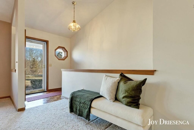 living area featuring baseboards and lofted ceiling