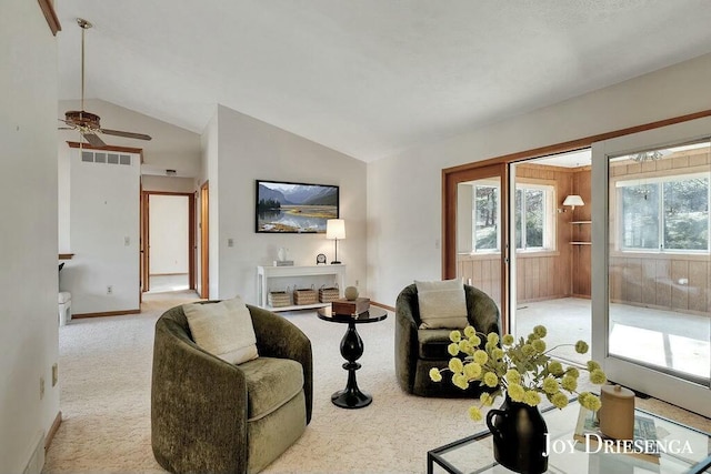 living area featuring lofted ceiling, light colored carpet, visible vents, and baseboards