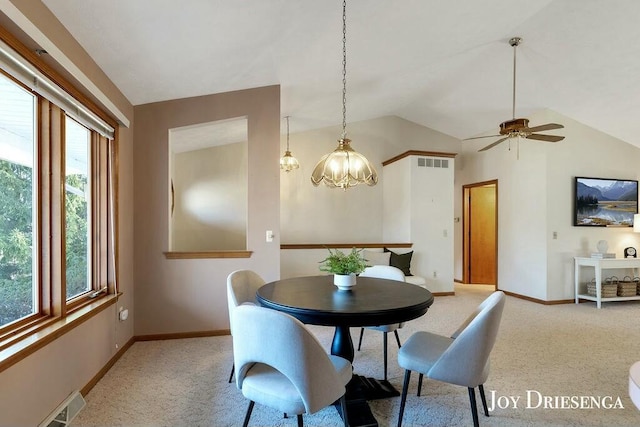 dining room with visible vents, lofted ceiling, light colored carpet, and baseboards