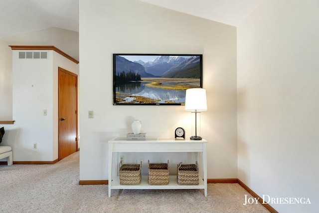 interior space with visible vents, carpet floors, baseboards, and vaulted ceiling