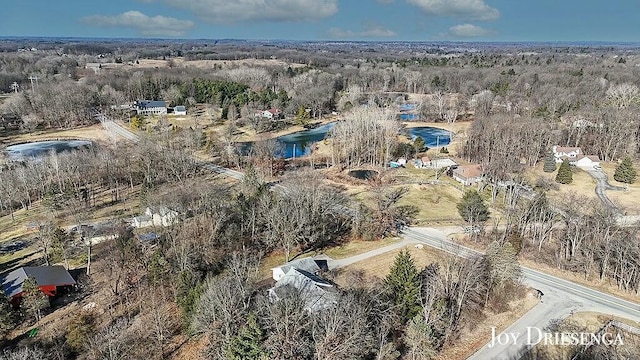 birds eye view of property featuring a forest view and a water view